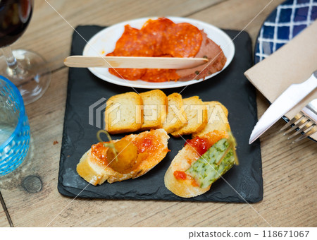 Assorted tapas served on black board in restaurant 118671067