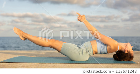 Yoga practice on embankment, female athlete fulfil carry out matsiasana Yoga practice on embankment, female athlete fulfil carry out matsiasana 118671248