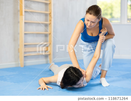 Two women training self-defense techniques in studio Two women training self-defense techniques in studio 118671264