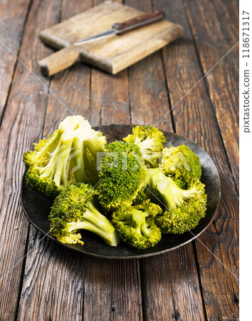 Boiling broccoli on black plate, preparing a healthy meal Boiling broccoli on black plate, preparing a healthy meal 118671317