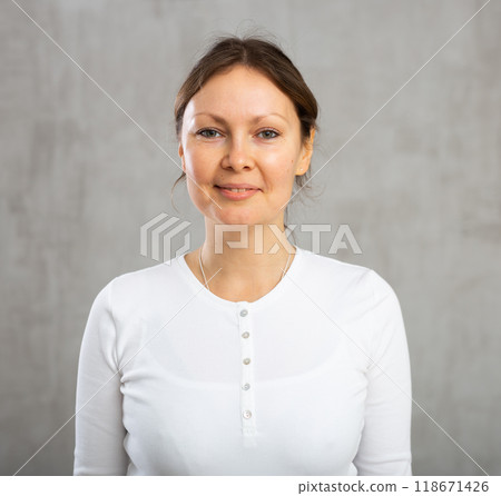 Portrait of smiling adult woman posing in studio 118671426