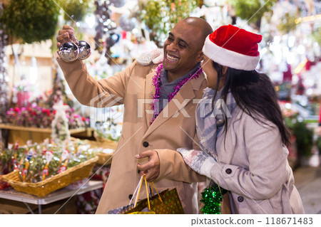 Emotional happy couple buying christmas balls at christmas fair 118671483