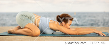 Yoga practice on embankment, female athlete fulfil carry out ashtangasana 118671489
