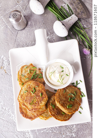 Fried potato pancakes with white sauce on plate Fried potato pancakes with white sauce on plate 118671607