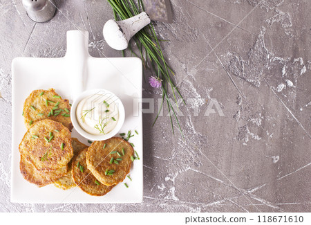 Fried potato pancakes with white sauce on plate Fried potato pancakes with white sauce on plate 118671610