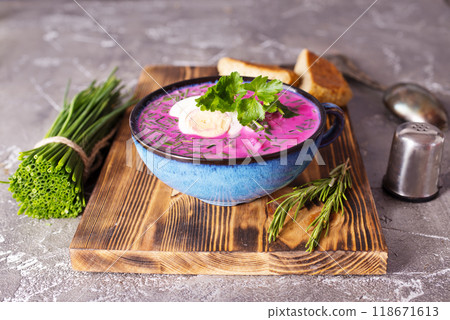 Traditional east european soup. Cold summer soup of beets, kefir, cucumbers, eggs and dill in a blue bowl closeup. 118671613