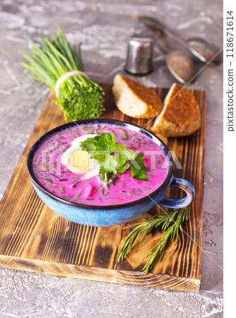 Traditional east european soup. Cold summer soup of beets, kefir, cucumbers, eggs and dill in a blue bowl closeup. 118671614