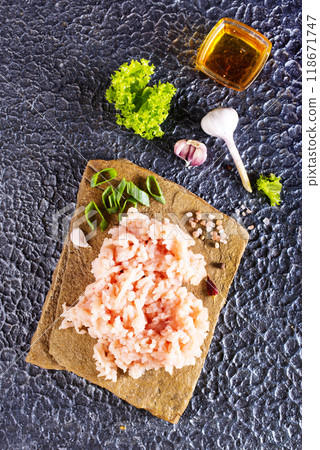 Raw minced meat in bowl on dark table and ingredients. 118671747