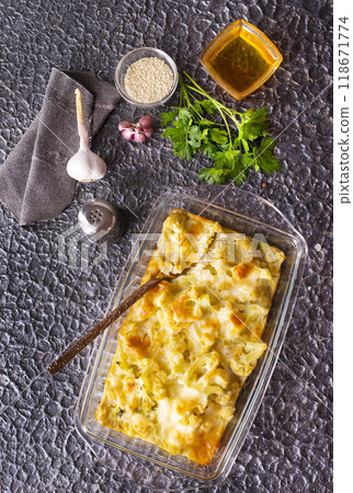 Cauliflower cheese in a baking dish on stone table 118671774