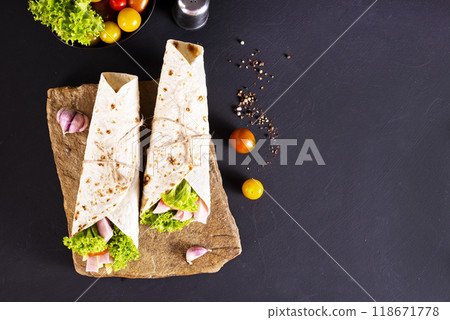 wrap sandwich with ham, lettuce, tomatoes and cheeses 118671778
