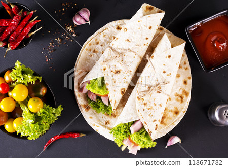wrap sandwich with ham, lettuce, tomatoes and cheeses 118671782