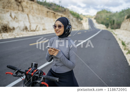female athlete using phone riding bike 118672091