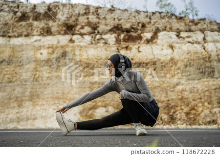 sporty hijab woman warming up before exercise 118672228