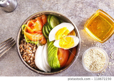 Healthy vegan nutritious bowl with buckwheat. Salad of avocado, salmon, buckwheat, egg and tomato Healthy vegan nutritious bowl with buckwheat. Salad of avocado, salmon, buckwheat, egg and tomato 118672230