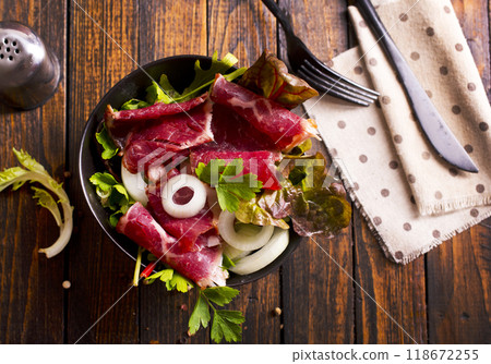 Sliced Pastrami roasted beef meat with herbs and vegetables 118672255