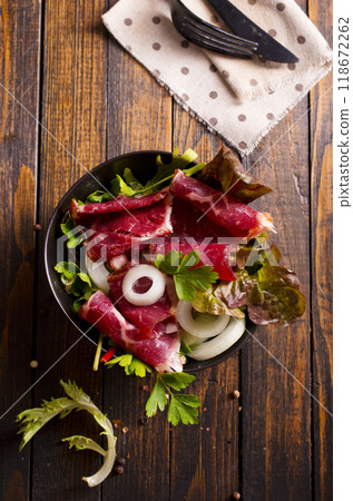 Sliced Pastrami roasted beef meat with herbs and vegetables 118672262