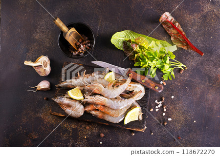 Raw tiger white shrimp prawn on board with herbs. Dark background. Top view. Raw tiger white shrimp prawn on board with herbs. Dark background. Top view. 118672270