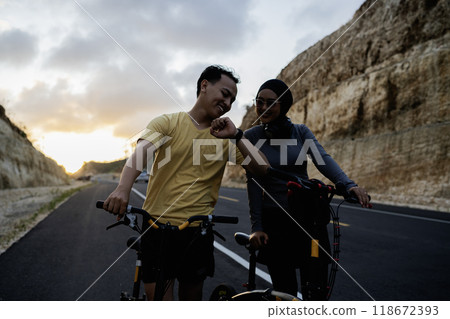 male biker showing smartwatch to female partner 118672393