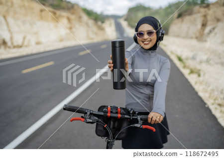 hijab woman holding bottle water with blurred background 118672495