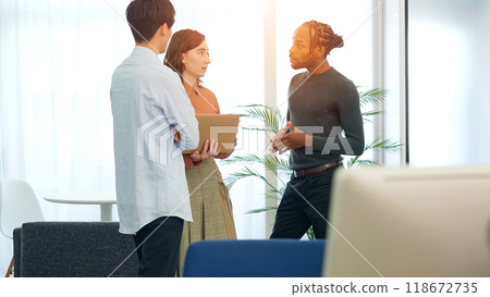 跨國人士在辦公室裡一邊看著筆記型電腦一邊交談 跨國人士在辦公室裡一邊看著筆記型電腦一邊交談 118672735