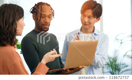 跨國人士在辦公室裡一邊看著筆記型電腦一邊交談 跨國人士在辦公室裡一邊看著筆記型電腦一邊交談 118672737
