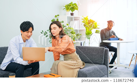 跨國人士在大廳一邊看著筆記型電腦一邊交談 118672740