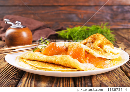 Pancakes with salmon (trout). Thin, not sweet blinchiki stuffed with red fish. Pancakes with salmon (trout). Thin, not sweet blinchiki stuffed with red fish. 118673544
