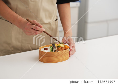 A scene where a mother makes a lunch box in the kitchen A scene where a mother makes a lunch box in the kitchen 118674597