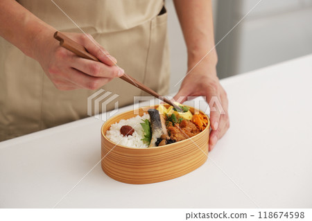 A scene where a mother makes a lunch box in the kitchen A scene where a mother makes a lunch box in the kitchen 118674598