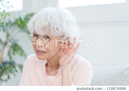 Elderly woman who is hard of hearing Elderly woman who is hard of hearing 118674998