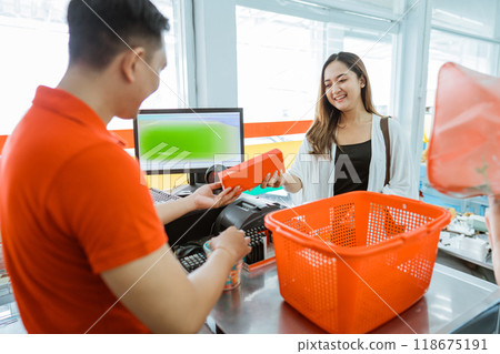 Male store clerk hands items to a female customer from the cart 118675191