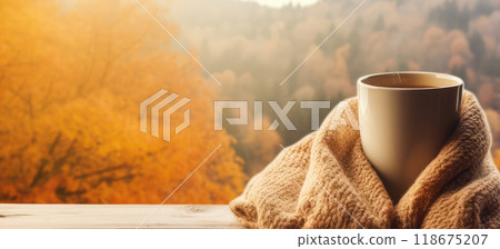 Ai generated Cup of coffee wrapped in cozy scarf and autumn leaves on windowsill with autumn park  118675207