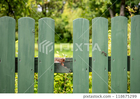 Missing board on wooden and broken fence 118675299