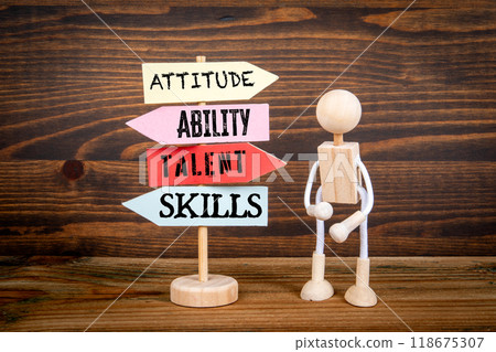 ATTITUDE ABILITY TALENT SKILLS. Miniature road sign arrows on wood texture background ATTITUDE ABILITY TALENT SKILLS. Miniature road sign arrows on wood texture background 118675307