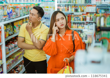 husband and wife confused to choose when shopping carrying a cart 118675341