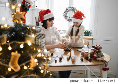 Mother and daughter baking together during Christmas holiday season 118675361