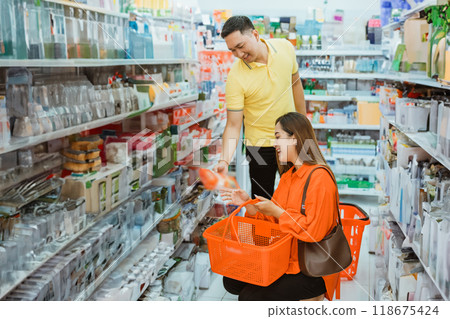 young man gives items to young woman while squatting down 118675424