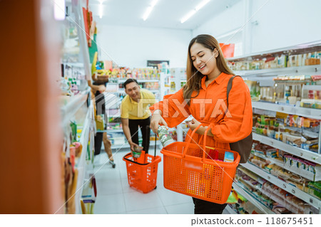 Asian woman putting some items in her shopping cart while shopping 118675451