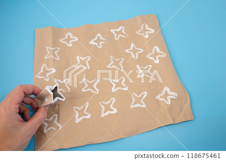 Folded paper roll into a star shape for DIY kids activity, perfect for making unique wrapping paper designs. Creative and fun crafting tutorial using recycled materials for holiday projects. 118675461