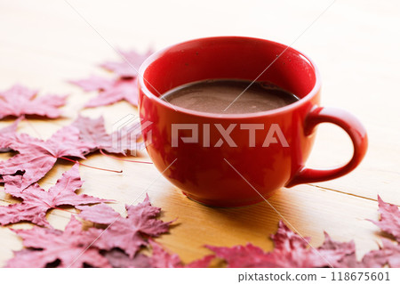 Cup of delicious hot chocolate with red maple leaf on wooden table background. Copy space. Selective focus. 118675601