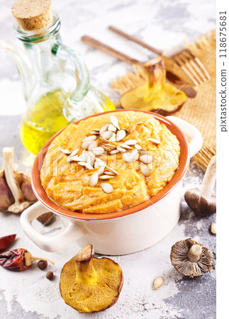 Vegetarian autumn pumpkin cream soup with mushrooms and seeds 118675681