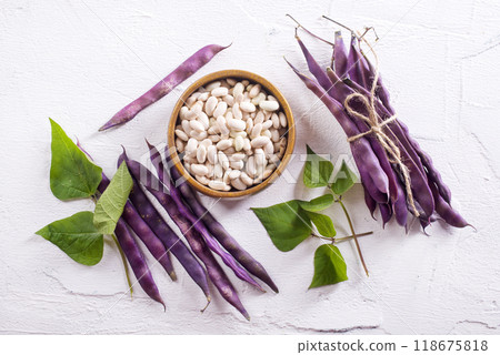 Uncooked dried white haricot beans in bowl n on table. Heap of legume haricot bean background Uncooked dried white haricot beans in bowl n on table. Heap of legume haricot bean background 118675818