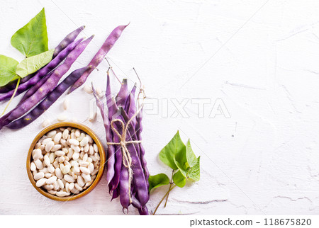 Uncooked dried white haricot beans in bowl n on table. Heap of legume haricot bean background Uncooked dried white haricot beans in bowl n on table. Heap of legume haricot bean background 118675820