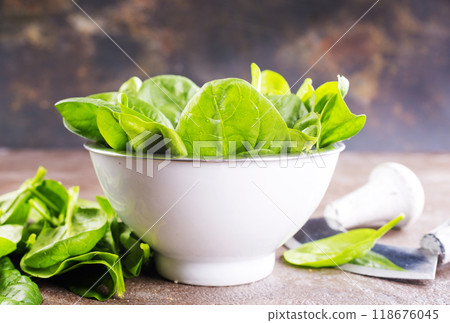 Heap of baby spinach leaves on a table Heap of baby spinach leaves on a table 118676045