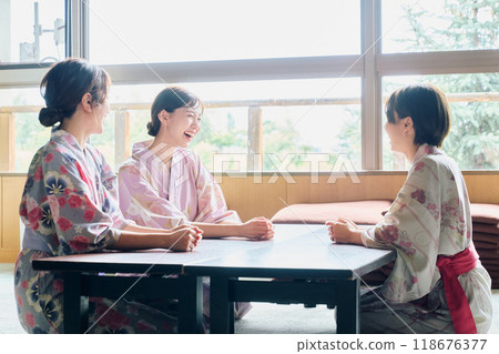 Women conversing at an inn Women conversing at an inn 118676377