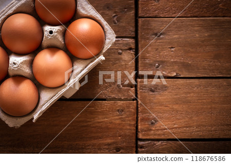 Egg box on a rustic wooden board 118676586