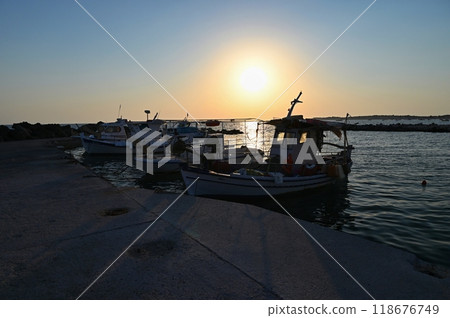 Small fishing boats in the harbor at sunset. Concept for travel and summer vacation. Greece-island of Corfu. Small fishing boats in the harbor at sunset. Concept for travel and summer vacation. Greece-island of Corfu. 118676749