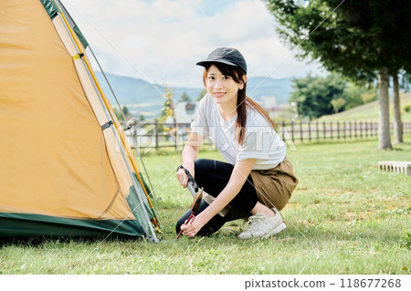 Woman assembling a tent 118677268