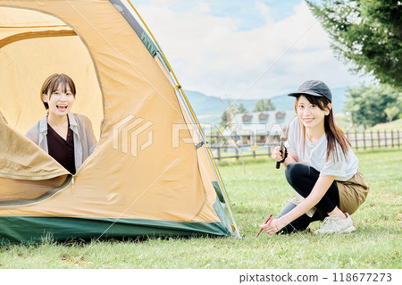Woman assembling a tent 118677273