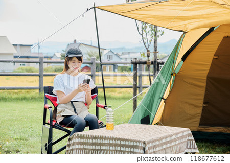 A woman working remotely at a campsite A woman working remotely at a campsite 118677612